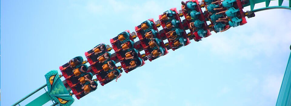 people on a colorful roller coaster on a sunny day