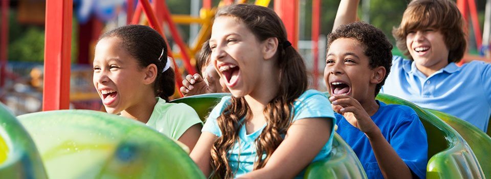 a group of children laugh on a roller coaster