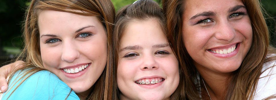 three young women smile into the camera